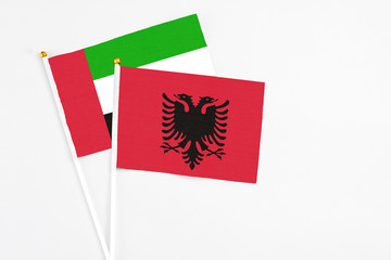 Albania and United Arab Emirates stick flags on white background. High quality fabric, miniature national flag. Peaceful global concept.White floor for copy space.