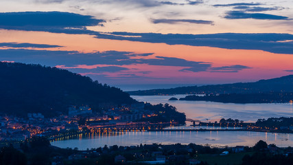 Serene night panorama of the medieval fishing town of Pontedeume with its iron and stone bridge blue and magenta sky La Coruña Galicia