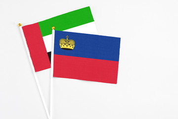 Liechtenstein and United Arab Emirates stick flags on white background. High quality fabric, miniature national flag. Peaceful global concept.White floor for copy space.