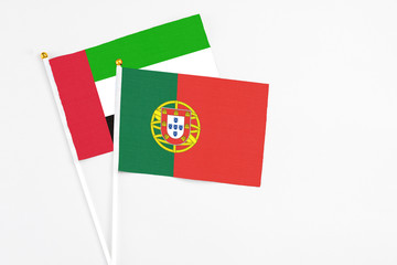 Portugal and United Arab Emirates stick flags on white background. High quality fabric, miniature national flag. Peaceful global concept.White floor for copy space.