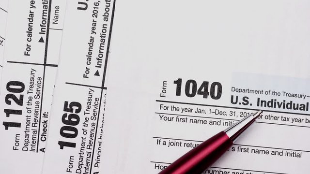 USA tax forms with money and pen. Tax Form 1040, 1120, 1065 and dollar bills, close up