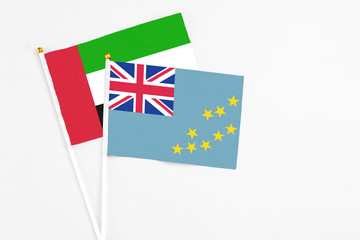 Fototapeta premium Tuvalu and United Arab Emirates stick flags on white background. High quality fabric, miniature national flag. Peaceful global concept.White floor for copy space.