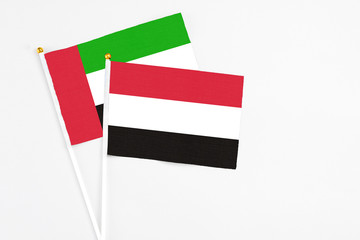 Yemen and United Arab Emirates stick flags on white background. High quality fabric, miniature national flag. Peaceful global concept.White floor for copy space.