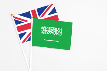 Saudi Arabia and United Kingdom stick flags on white background. High quality fabric, miniature national flag. Peaceful global concept.White floor for copy space.