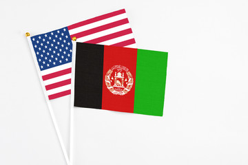 Afghanistan and United States stick flags on white background. High quality fabric, miniature national flag. Peaceful global concept.White floor for copy space.