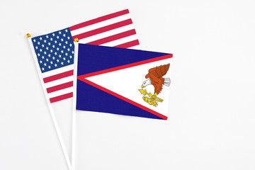American Samoa and United States stick flags on white background. High quality fabric, miniature national flag. Peaceful global concept.White floor for copy space.
