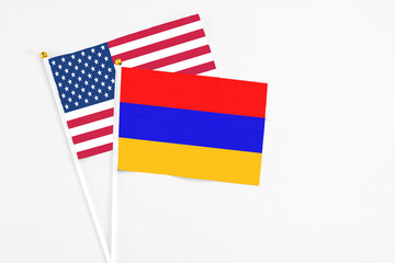 Armenia and United States stick flags on white background. High quality fabric, miniature national flag. Peaceful global concept.White floor for copy space.