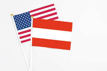 Austria and United States stick flags on white background. High quality fabric, miniature national flag. Peaceful global concept.White floor for copy space.