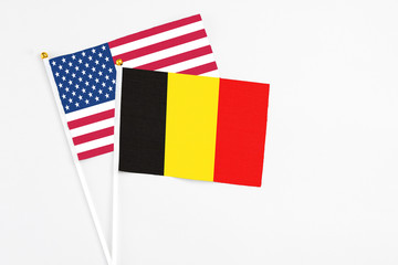 Belgium and United States stick flags on white background. High quality fabric, miniature national flag. Peaceful global concept.White floor for copy space.