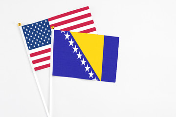 Bosnia Herzegovina and United States stick flags on white background. High quality fabric, miniature national flag. Peaceful global concept.White floor for copy space.
