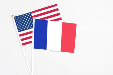 France and United States stick flags on white background. High quality fabric, miniature national flag. Peaceful global concept.White floor for copy space.