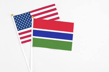 Gambia and United States stick flags on white background. High quality fabric, miniature national flag. Peaceful global concept.White floor for copy space.