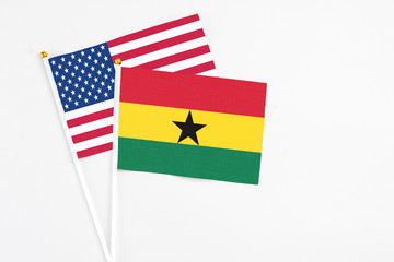 Ghana and United States stick flags on white background. High quality fabric, miniature national flag. Peaceful global concept.White floor for copy space.