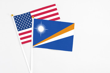 Marshall Islands and United States stick flags on white background. High quality fabric, miniature national flag. Peaceful global concept.White floor for copy space.