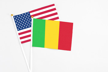 Mali and United States stick flags on white background. High quality fabric, miniature national flag. Peaceful global concept.White floor for copy space.