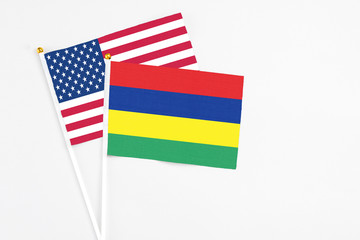 Mauritius and United States stick flags on white background. High quality fabric, miniature national flag. Peaceful global concept.White floor for copy space.