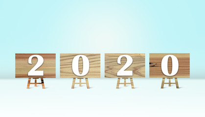 Happy new year 2020 with wood board on white floor and light blue background. Holiday celebration concept.