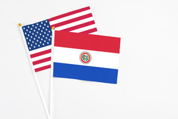 Paraguay and United States stick flags on white background. High quality fabric, miniature national flag. Peaceful global concept.White floor for copy space.