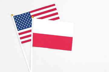 Poland and United States stick flags on white background. High quality fabric, miniature national flag. Peaceful global concept.White floor for copy space.