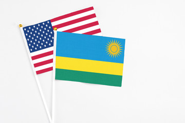 Rwanda and United States stick flags on white background. High quality fabric, miniature national flag. Peaceful global concept.White floor for copy space.
