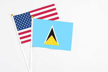 Saint Lucia and United States stick flags on white background. High quality fabric, miniature national flag. Peaceful global concept.White floor for copy space.