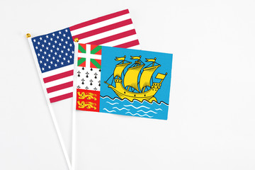 Saint Pierre And Miquelon and United States stick flags on white background. High quality fabric, miniature national flag. Peaceful global concept.White floor for copy space.