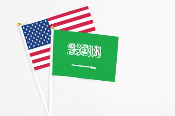 Obraz premium Saudi Arabia and United States stick flags on white background. High quality fabric, miniature national flag. Peaceful global concept.White floor for copy space.
