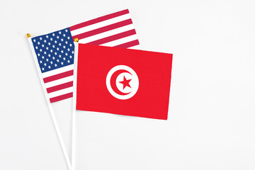 Tunisia and United States stick flags on white background. High quality fabric, miniature national flag. Peaceful global concept.White floor for copy space.