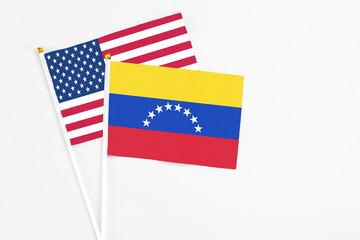 Venezuela and United States stick flags on white background. High quality fabric, miniature national flag. Peaceful global concept.White floor for copy space.