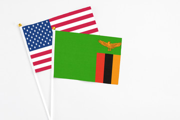 Zambia and United States stick flags on white background. High quality fabric, miniature national flag. Peaceful global concept.White floor for copy space.
