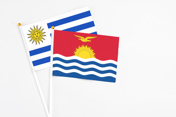 Kiribati and Uruguay stick flags on white background. High quality fabric, miniature national flag. Peaceful global concept.White floor for copy space.