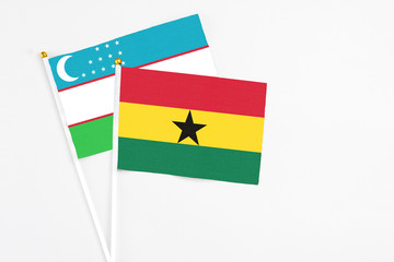 Ghana and Uzbekistan stick flags on white background. High quality fabric, miniature national flag. Peaceful global concept.White floor for copy space.