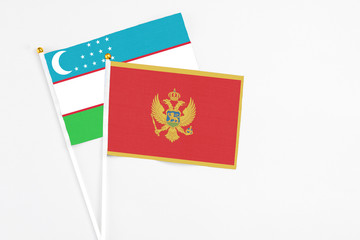 Montenegro and Uzbekistan stick flags on white background. High quality fabric, miniature national flag. Peaceful global concept.White floor for copy space.