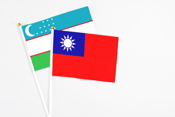 Taiwan and Uzbekistan stick flags on white background. High quality fabric, miniature national flag. Peaceful global concept.White floor for copy space.