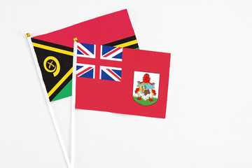 Bermuda and Vanuatu stick flags on white background. High quality fabric, miniature national flag. Peaceful global concept.White floor for copy space.