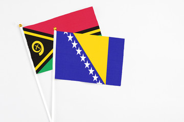 Bosnia Herzegovina and Vanuatu stick flags on white background. High quality fabric, miniature national flag. Peaceful global concept.White floor for copy space.