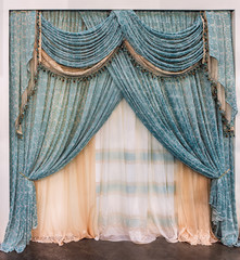 Luxurious green lace curtains in the palace style with fringe and pelmet