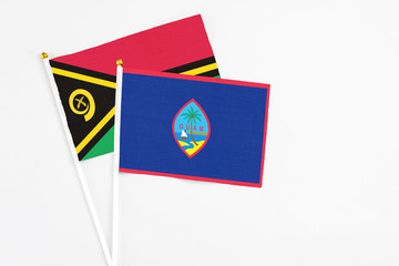 Guam and Vanuatu stick flags on white background. High quality fabric, miniature national flag. Peaceful global concept.White floor for copy space.