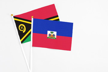 Haiti and Vanuatu stick flags on white background. High quality fabric, miniature national flag. Peaceful global concept.White floor for copy space.