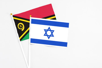 Israel and Vanuatu stick flags on white background. High quality fabric, miniature national flag. Peaceful global concept.White floor for copy space.