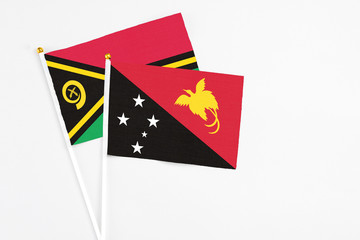 Papua New Guinea and Vanuatu stick flags on white background. High quality fabric, miniature national flag. Peaceful global concept.White floor for copy space.