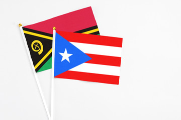Puerto Rico and Vanuatu stick flags on white background. High quality fabric, miniature national flag. Peaceful global concept.White floor for copy space.