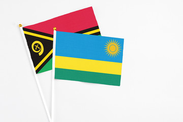 Rwanda and Vanuatu stick flags on white background. High quality fabric, miniature national flag. Peaceful global concept.White floor for copy space.