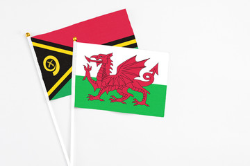 Wales and Vanuatu stick flags on white background. High quality fabric, miniature national flag. Peaceful global concept.White floor for copy space.