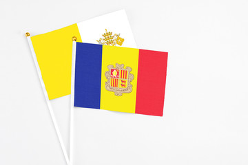 Andorra and Vatican City stick flags on white background. High quality fabric, miniature national flag. Peaceful global concept.White floor for copy space.