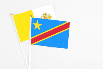 Congo and Vatican City stick flags on white background. High quality fabric, miniature national flag. Peaceful global concept.White floor for copy space.