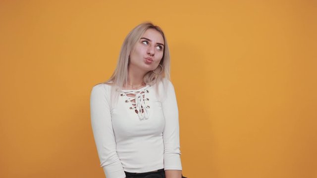 Young funny beautiful caucasian woman wearing nice white shirt puffing cheeks with funny face. Mouth inflated with air, crazy expression.