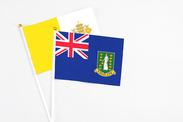 Fototapeta premium British Virgin Islands and Vatican City stick flags on white background. High quality fabric, miniature national flag. Peaceful global concept.White floor for copy space.