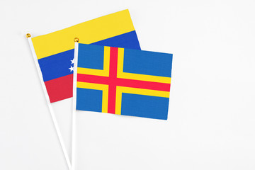 Aland Islands and Venezuela stick flags on white background. High quality fabric, miniature...