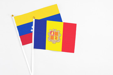 Andorra and Venezuela stick flags on white background. High quality fabric, miniature national flag. Peaceful global concept.White floor for copy space.